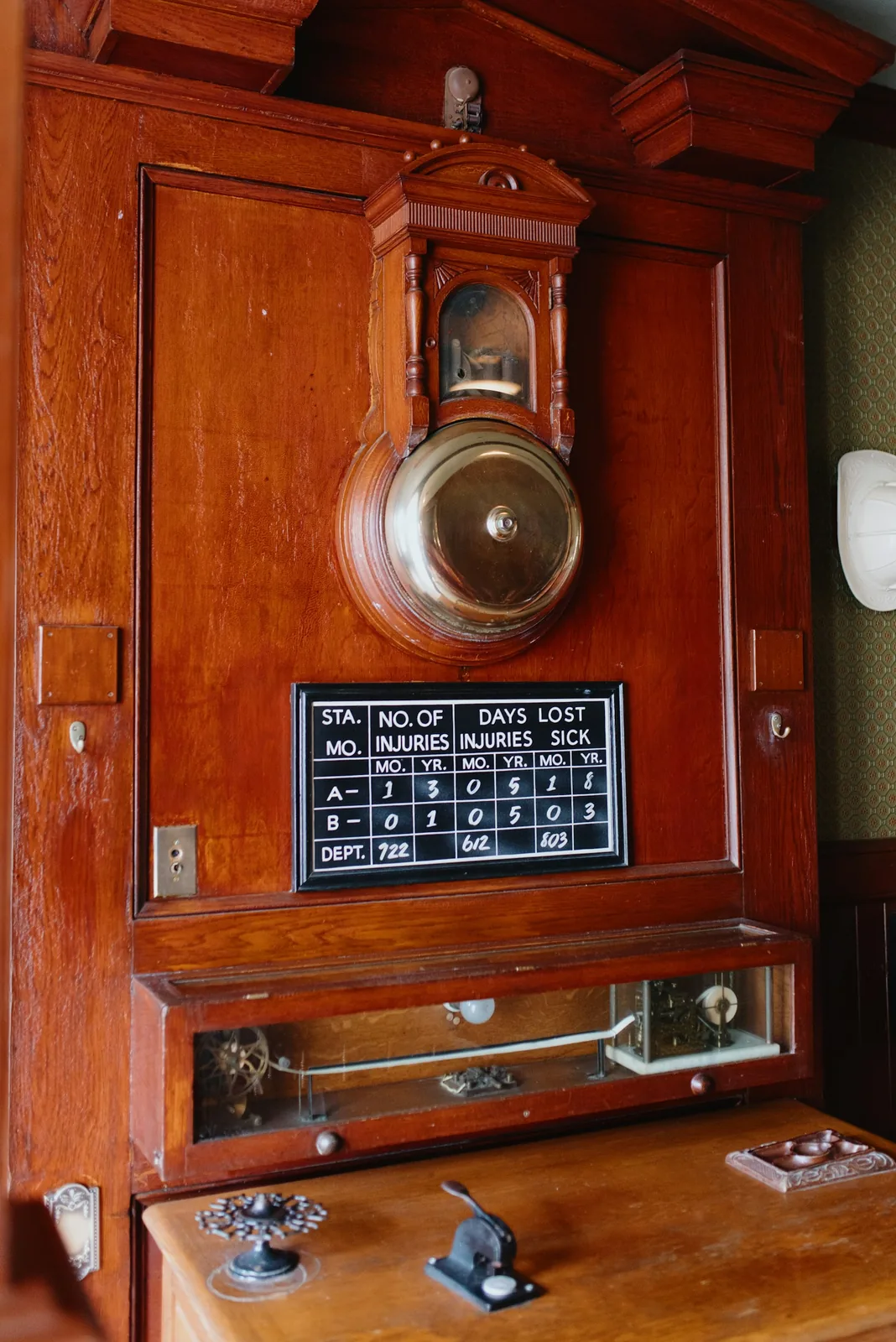 Antique wooden safety station with brass bell and mechanical gears.