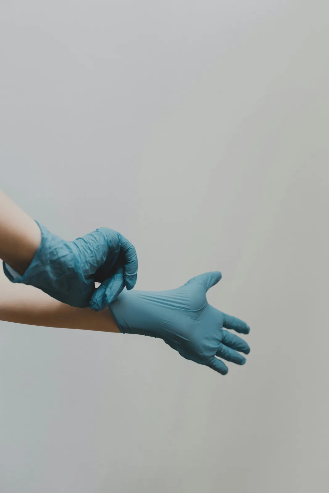 person putting on blue medical gloves