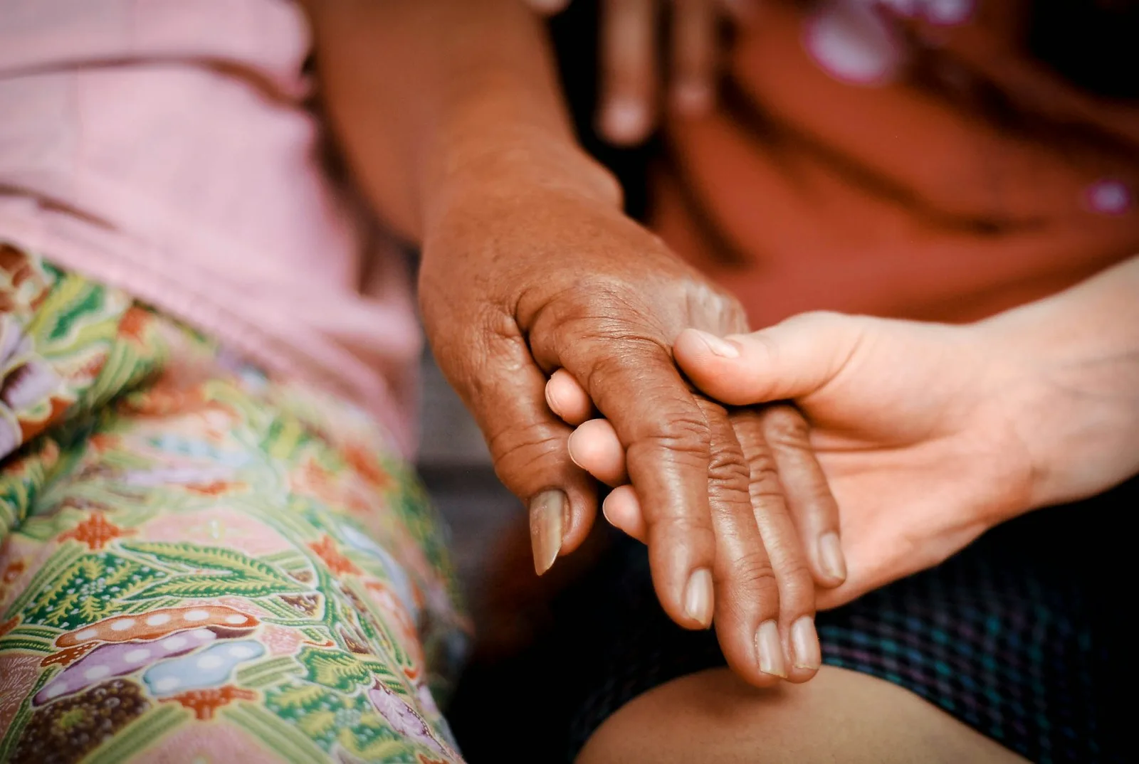 A close-up of two people holding hands