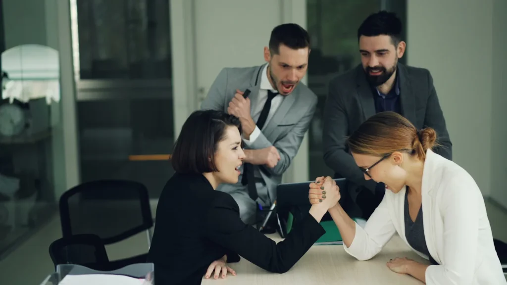 Two women arm wrestling at a table