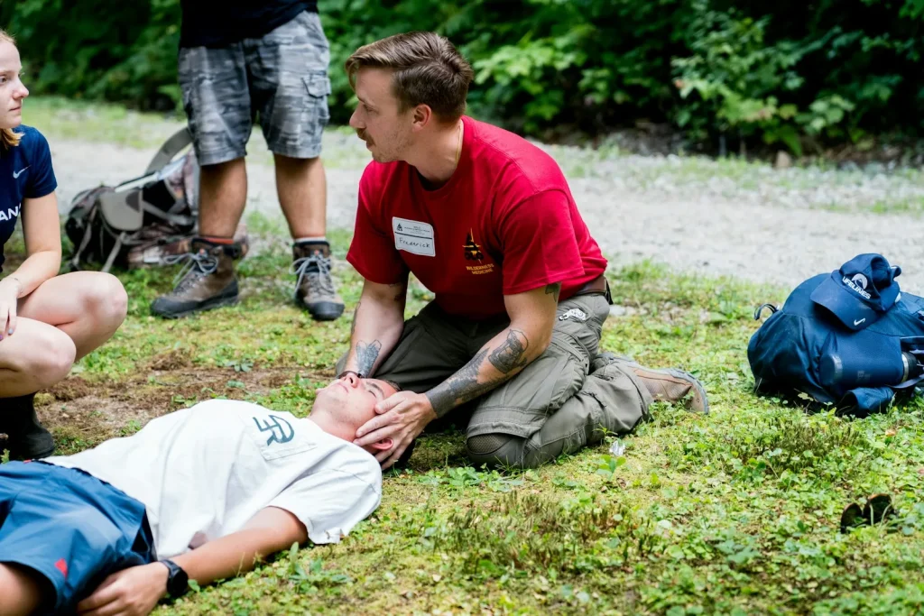 Man performs cpr on another man outdoors