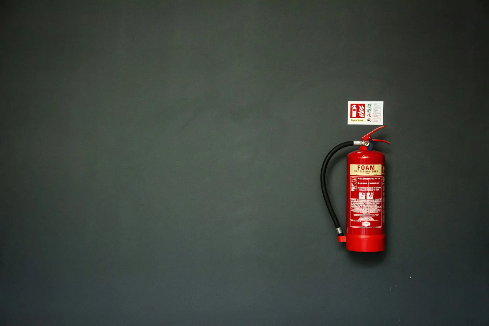 red fire extinguisher on gray wall