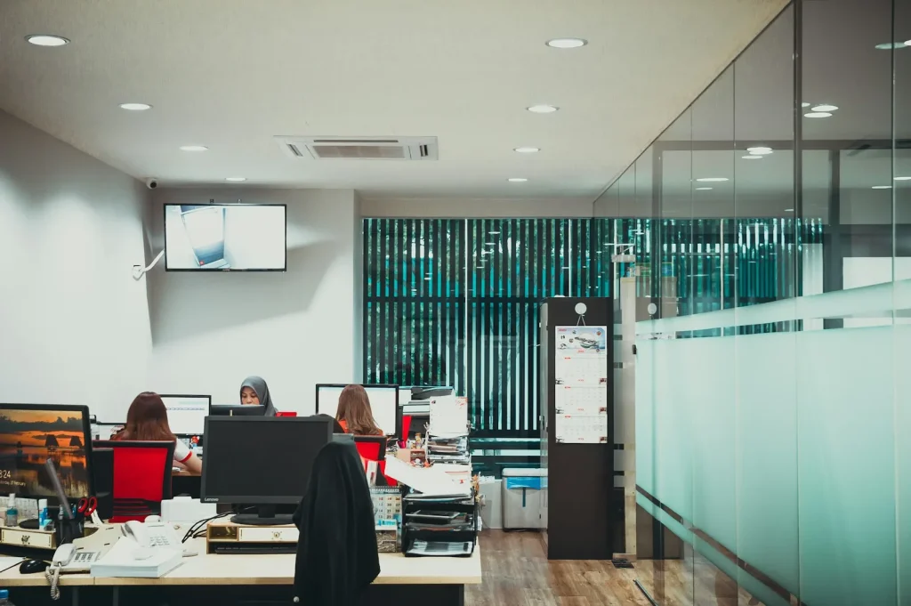 a group of people sitting at desks in an office