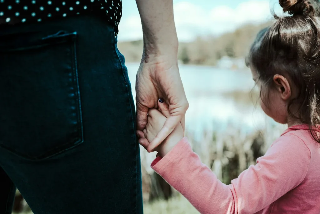 girl in pink jacket holding her hair