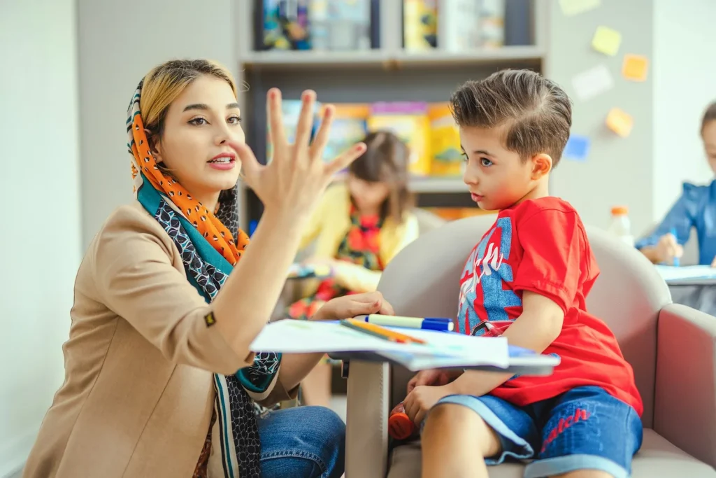 Teacher showing a child numbers with her fingers
