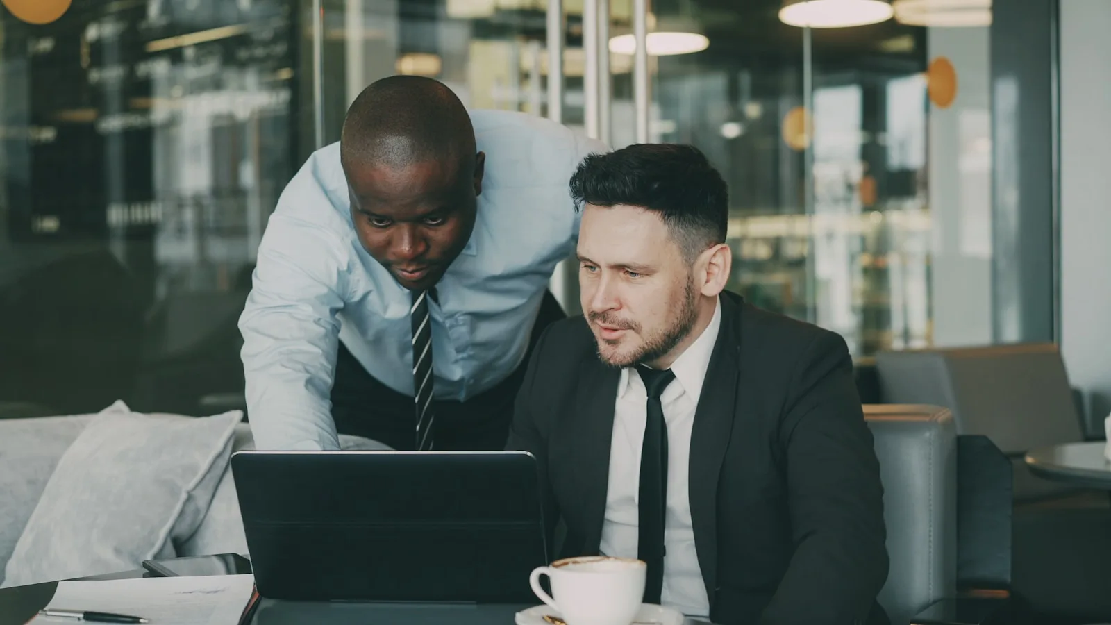 Two businessmen collaborating on a laptop
